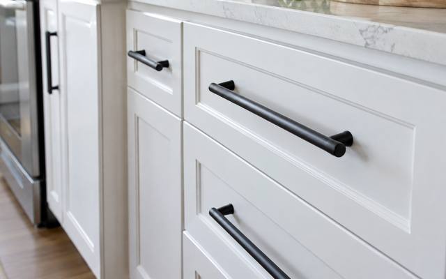 White painted drawers fitted with long black bar pulls.
